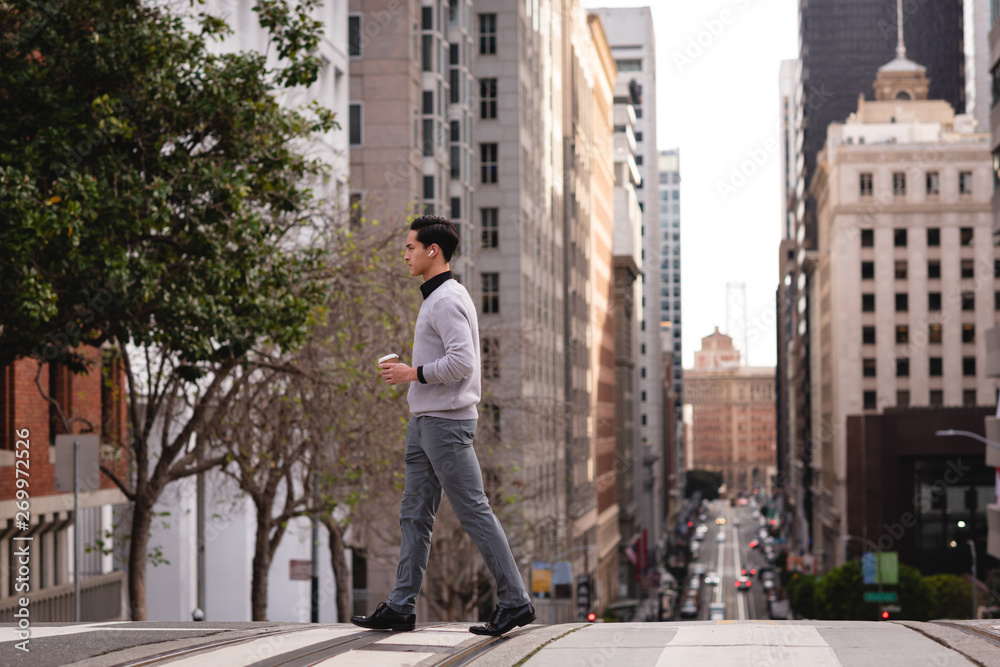 Man crossing the street while having coffee Man crossing the street while having coffee