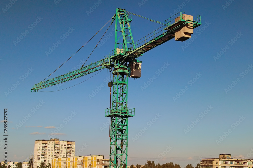 Green tower crane building the new residential building. Construction site, Kyiv, Ukraine