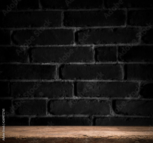 Old wooden table with brick background dark © kishivan