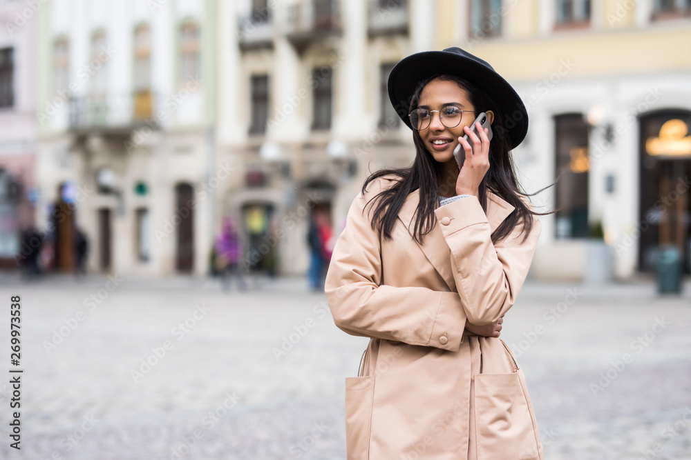Portrait young woman in black hat using mobile phone on city street Portrait young woman in black hat using mobile phone on city street