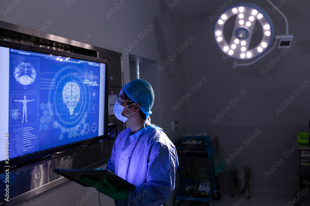 Male surgeon looking at screen in operating room at hospital Male surgeon looking at screen in operating room at hospital