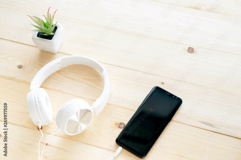 Smartphone and headphones on the table wood