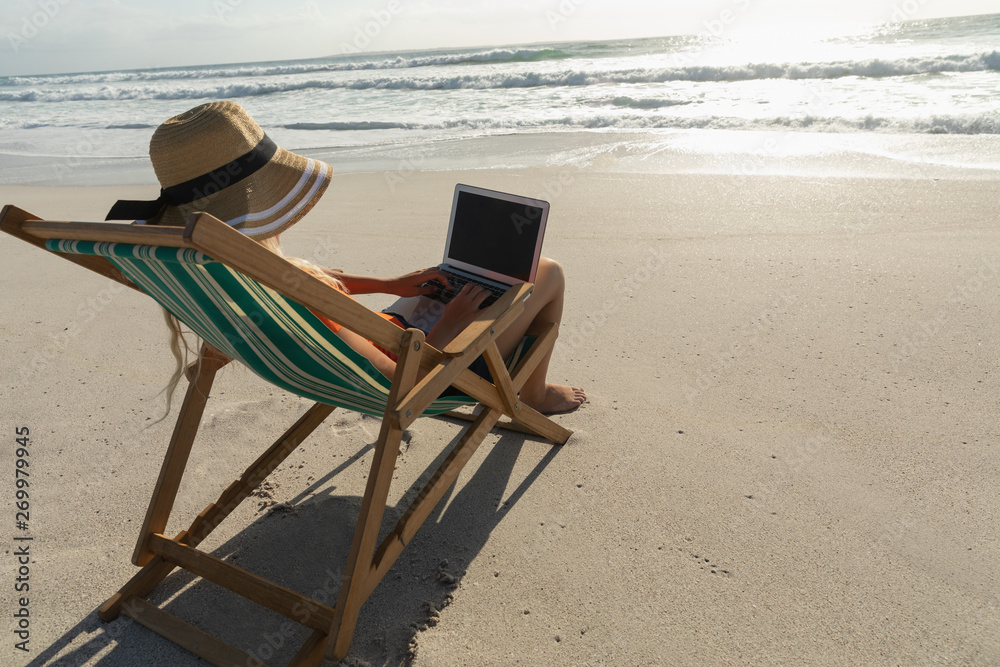 Young Caucasian woman relaxing on sun lounger at beach Young Caucasian woman relaxing on sun lounger at beach