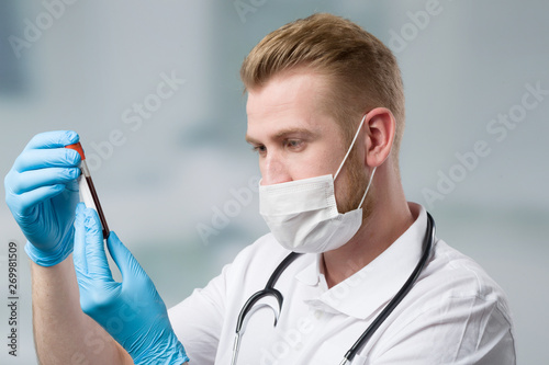 Scientist with medical face mask and blood probe