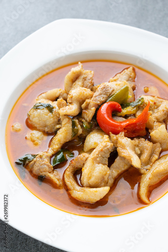 Spicy curry with pork in white dish on table.(Panang curry)