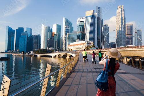 Young woman taking a photo with her phone in Singapore
