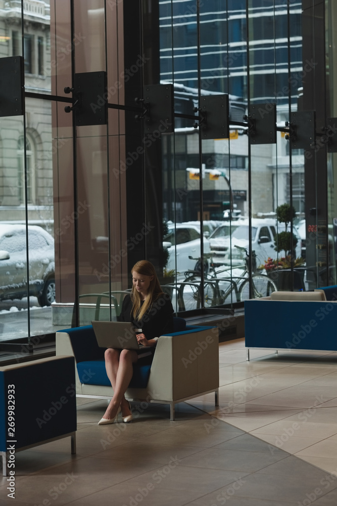 Businesswoman using laptop in the lobby Businesswoman using laptop in the lobby