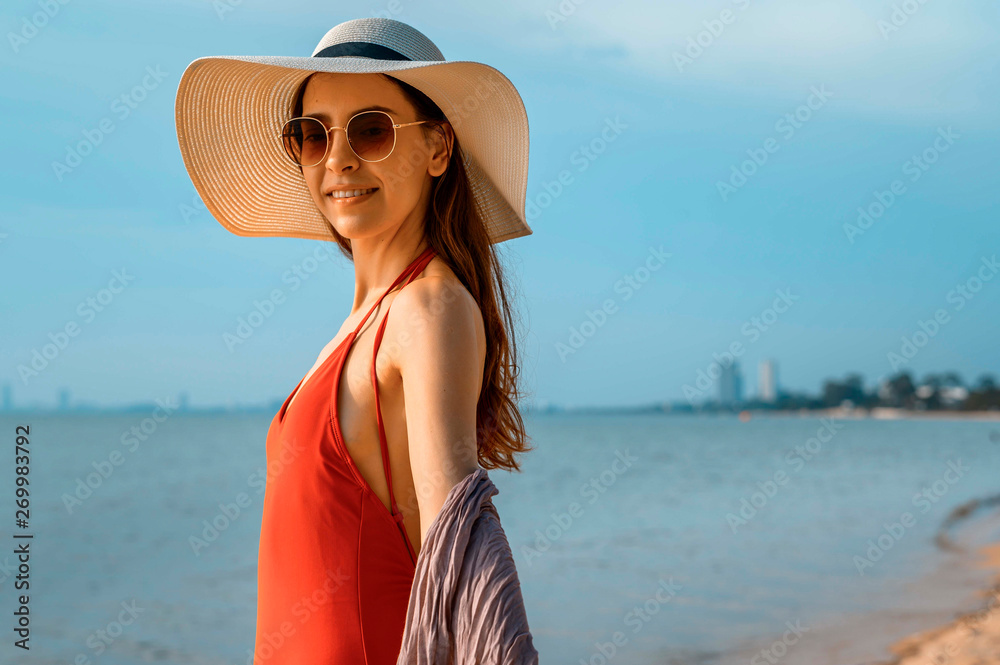 Beautiful woman with red swimsuit on the beach in Summer 
