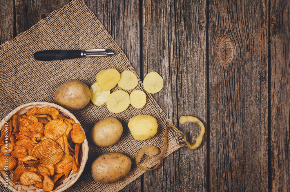 Fototapeta premium Heap of potato chips in vintage bowl on old wooden table background close-up with copy space for your text