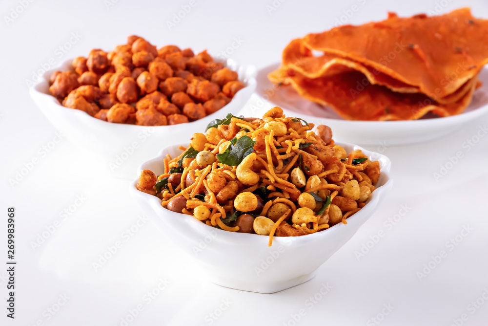 Assortment salty crunchy indian mix Nimco or Namkeen, spicy coated peanut and pappadam white bowl wooden background. Assortment salty crunchy indian mix Nimco or Namkeen, spicy coated peanut and pappadam white bowl wooden background.