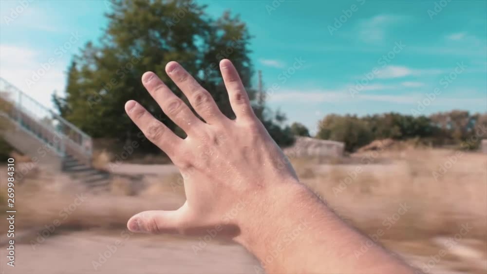 Enjoy trip concept. Hand is sticking out of car window, beautiful village road with wind in summer time. Blue sky, day hours. Enjoy trip concept. Hand is sticking out of car window, beautiful village road with wind in summer time. Blue sky, day hours.