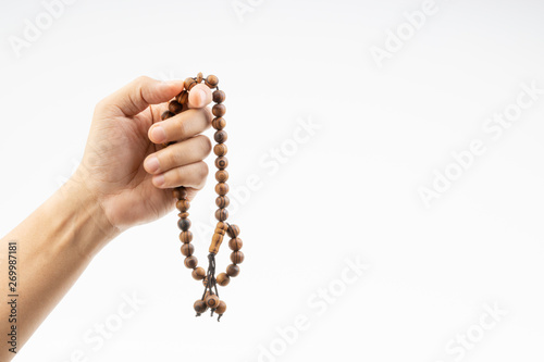Hand holding a muslim rosary beads or Tasbih on white background. Copy space and selective focus © instagram.com/_alfil