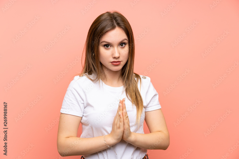 Fototapeta premium Teenager girl over isolated pink wall pleading