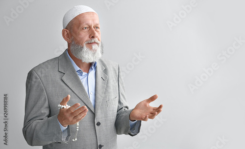 Senior Muslim man praying a...