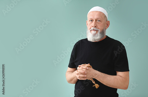 Senior Muslim man praying a...