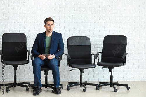 Young man waiting for job interview indoors © Pixel-Shot