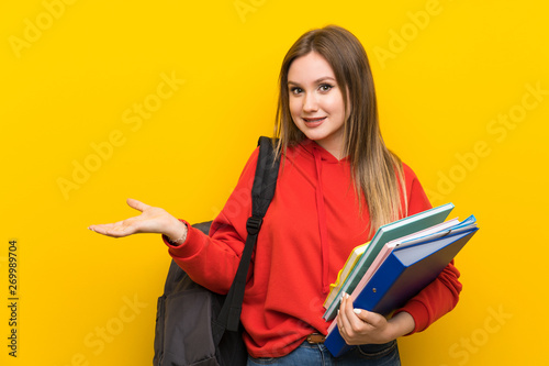 Teenager student girl over yellow background extending hands to the side for inviting to come