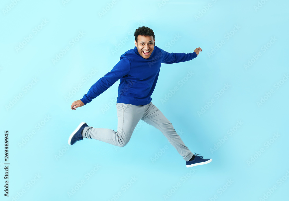 Handsome jumping man on color background