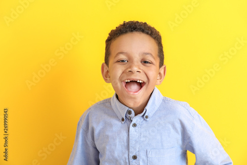 Laughing African-American boy on color background