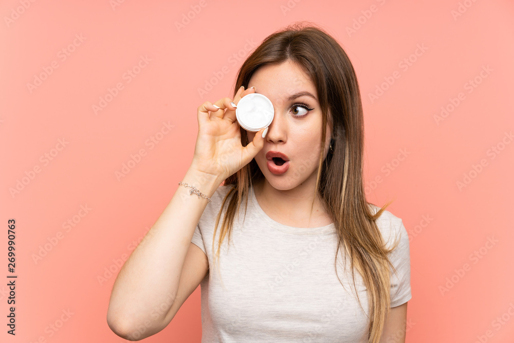 Teenager girl over pink background with moisturizer Teenager girl over pink background with moisturizer