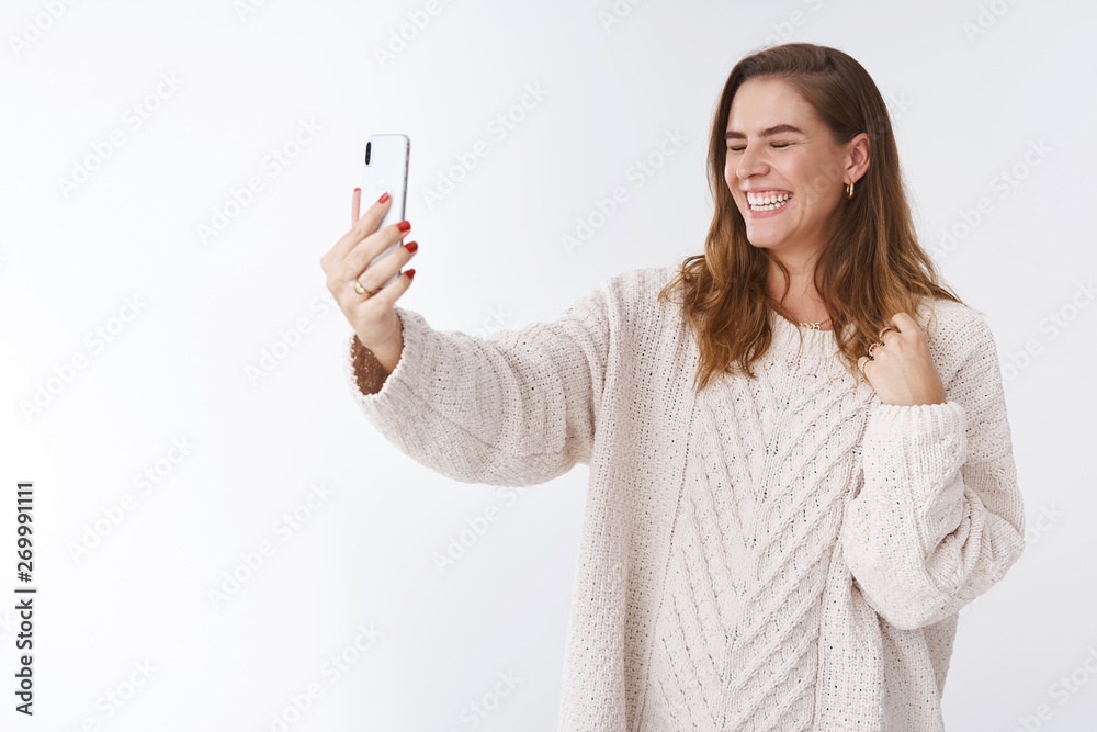 Carefree attractive charming charismatic european woman laughing out loud making video phone call extend arm smartphone close eyes giggling happily talking communicating online via internet Carefree attractive charming charismatic european woman laughing out loud making video phone call extend arm smartphone close eyes giggling happily talking communicating online via internet