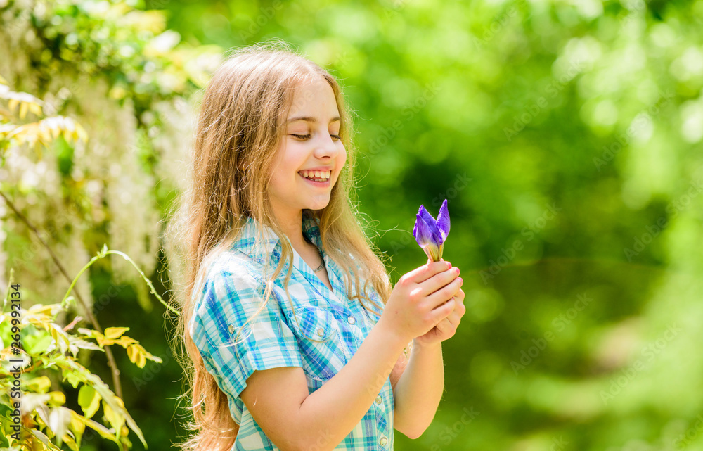 summer vacation. Green environment. happy child hold iris flower. little girl and iris flower. Natural beauty. Childhood happiness. florist. Spring holiday. Womens day. Young and carefree summer vacation. Green environment. happy child hold iris flower. little girl and iris flower. Natural beauty. Childhood happiness. florist. Spring holiday. Womens day. Young and carefree