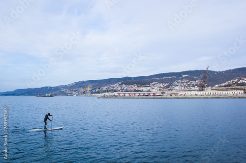 Surfer on stand up paddle board on trieste sea 