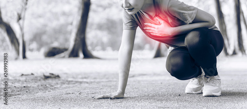 shot of young Asian women clutching his chest from acute pain or heart attack or cardiac arrest,severe heartache while exercise in park. emergency, First Aid, life and medical concept