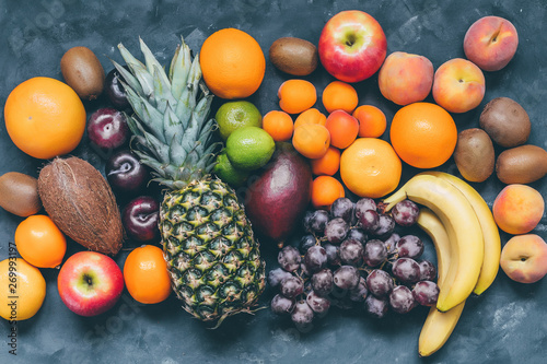 Fototapeta Naklejka Na Ścianę i Meble -  Assortment of fruit pineapple,pitaya,bananas, mango,  grapes, orange, apple, coconut, peaches, apricots, tangerines, lemon and kiwi top view