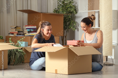 Happy rommates unboxing belongings moving home photo