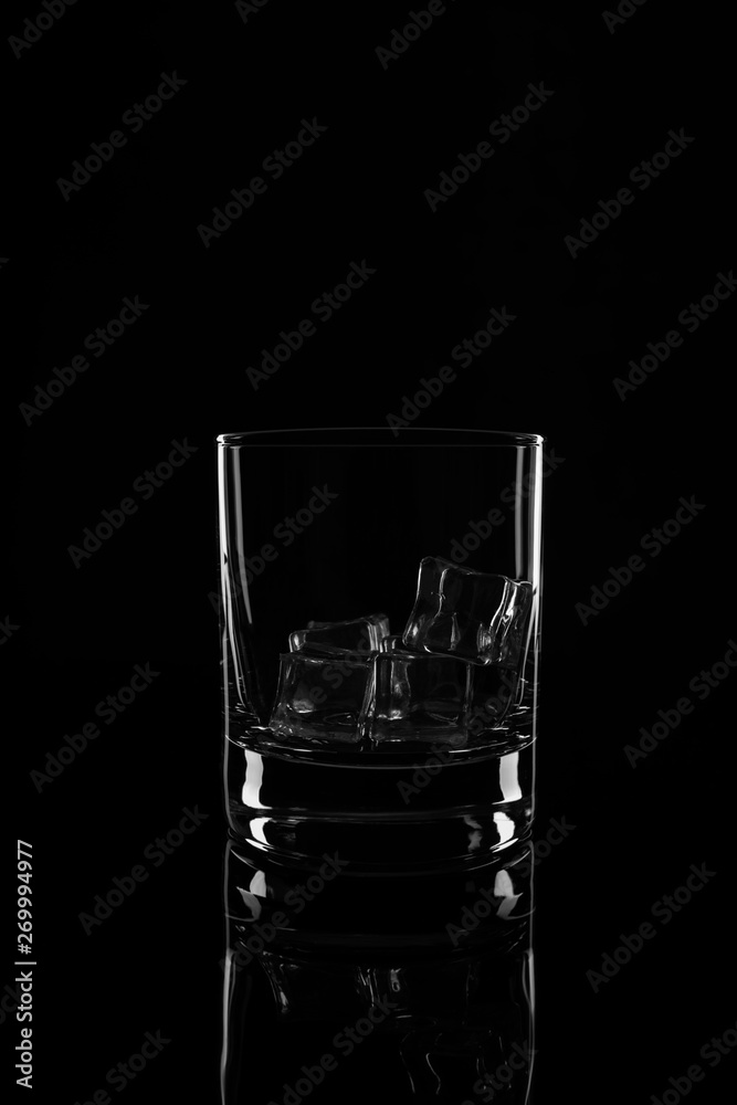 Glass with ice cubes, isolated on a black background