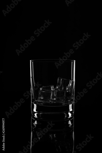 Glass with ice cubes, isolated on a black background