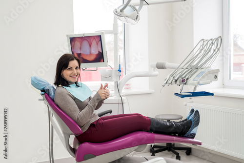 Woman sitting in dentist's chair and smiling