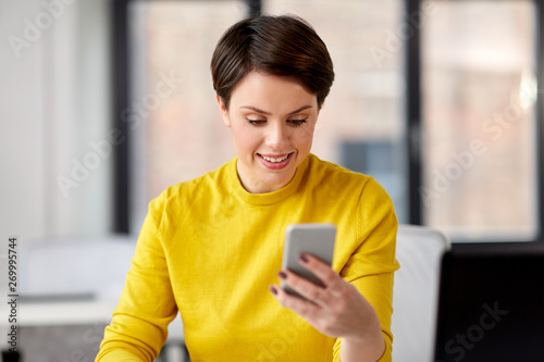 business, technology and people concept - businesswoman with smartphone working at office © Syda Productions