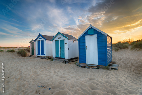 Sunset over a row of pretty beach huts at Southwold