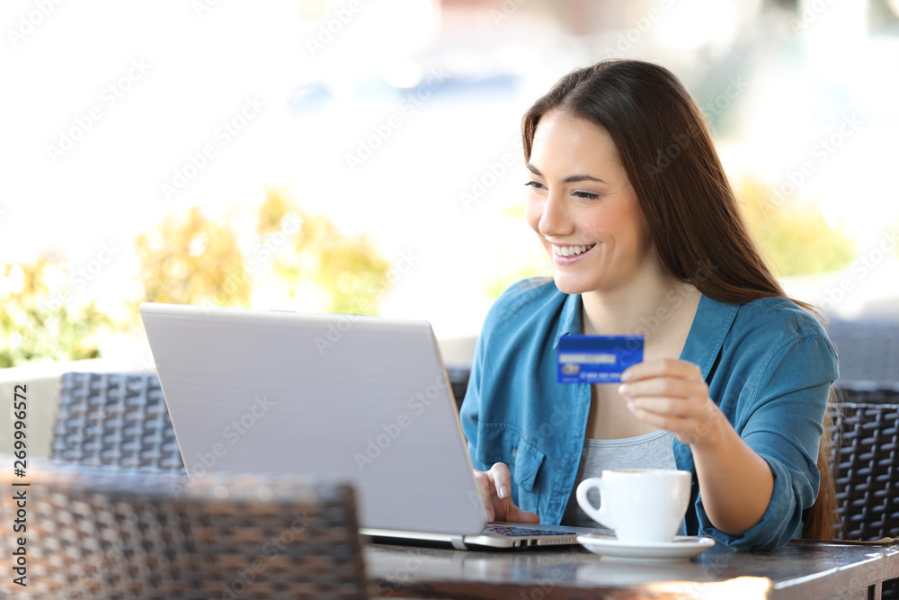Happy woman buying online paying with a credit card Happy woman buying online paying with a credit card