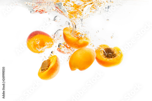 Bunch of apricots halves dropped into water