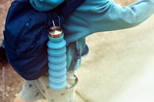 Reusable eco friendly water bottle on child's backpack