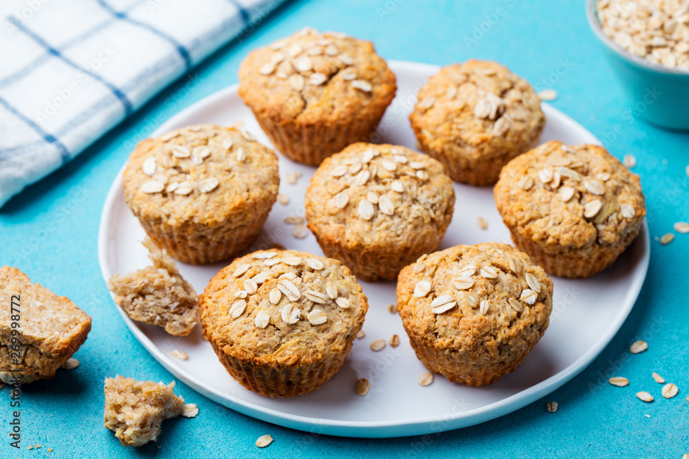 Healthy vegan oat muffins, apple and banana cakes with on a white plate. Blue background. Healthy vegan oat muffins, apple and banana cakes with on a white plate. Blue background.