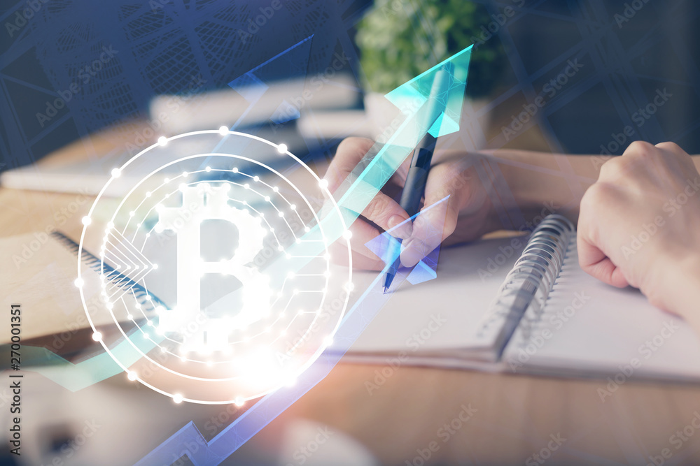 Cryptocurrency hologram, bitcoin, ico theme over hands taking notes background. Concept of blockchain. Multi exposure Cryptocurrency hologram, bitcoin, ico theme over hands taking notes background. Concept of blockchain. Multi exposure