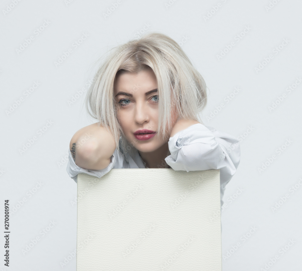 Horizontal portrait of a beautiful girl with blond hair sitting on a chair. Horizontal portrait of a beautiful girl with blond hair sitting on a chair.