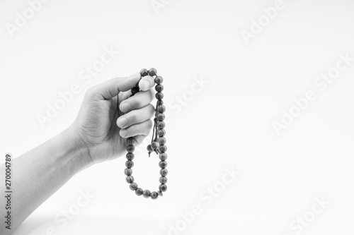 Hand holding a muslim rosary beads or Tasbih on black and white. Copy space and selective focus