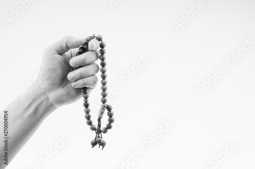 Hand holding a muslim rosary beads or Tasbih on black and white. Copy space and selective focus