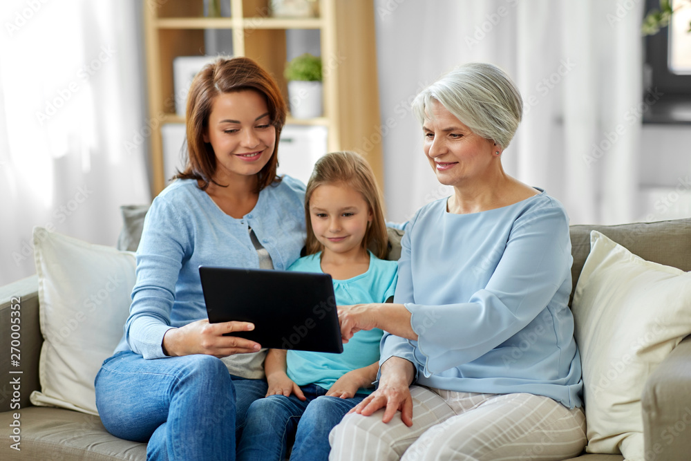 family, generation and technology concept - happy mother, daughter and grandmother with tablet computer at home