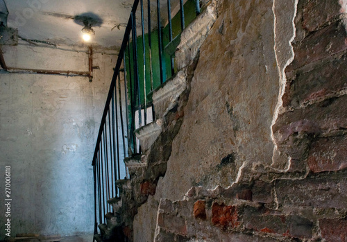 Old ruined abandoned haunted house interior.Dimly lit room with cracked brick and concrete walls.Ghetto neighborhood slums.Destroyed urban architecture.Creepy industrial building inside.Dirty stairway