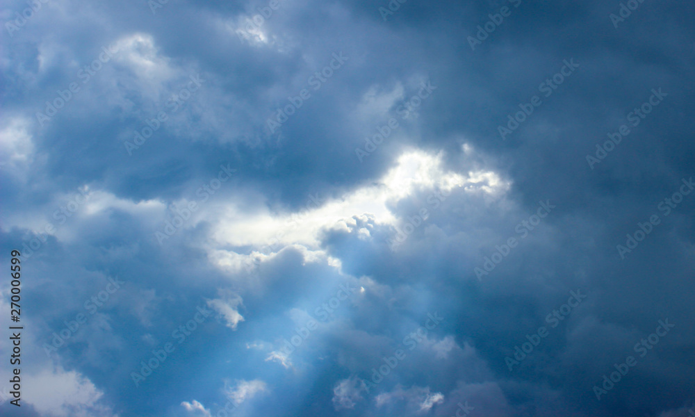Close-up of rays of sunlight through puffy clouds Close-up of rays of sunlight through puffy clouds
