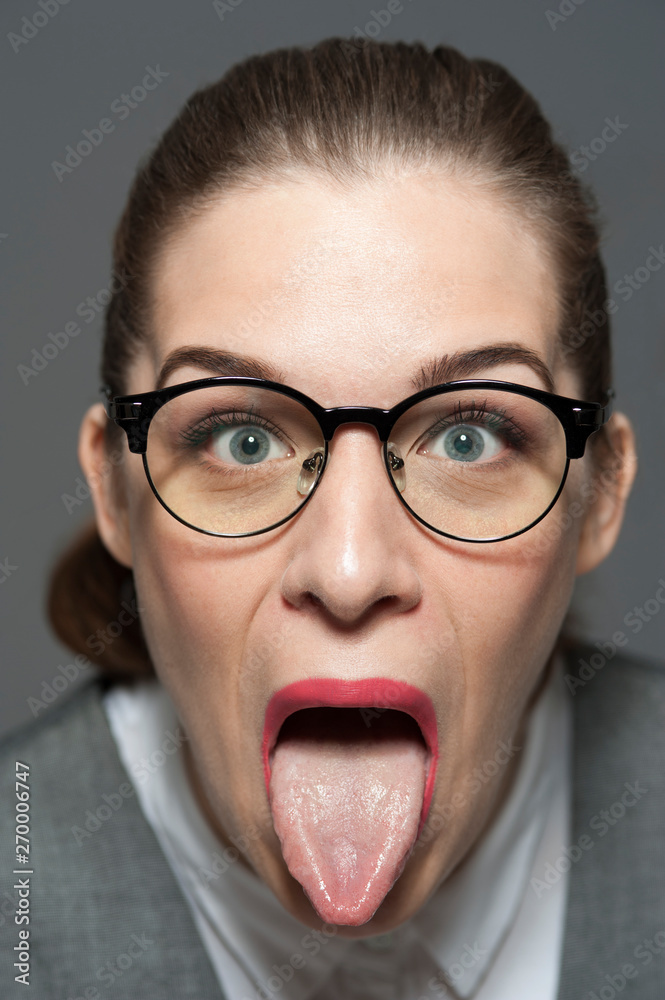 Funny young woman showing her tongue