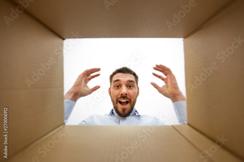 Slika na platnu emotions, delivery and surprise concept - happy suprised man looking into open p