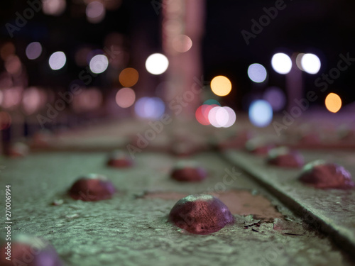 Perspective view of old rusty steel structure with metal bolts with specular highlights or bokeh balls in the background. Abstract image of industrial city in the night. photo