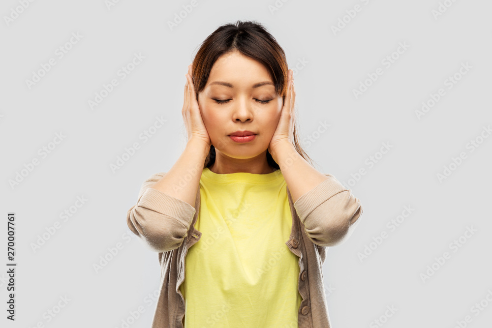 people, emotion and stress concept - asian young woman closing ears by hands over grey background people, emotion and stress concept - asian young woman closing ears by hands over grey background